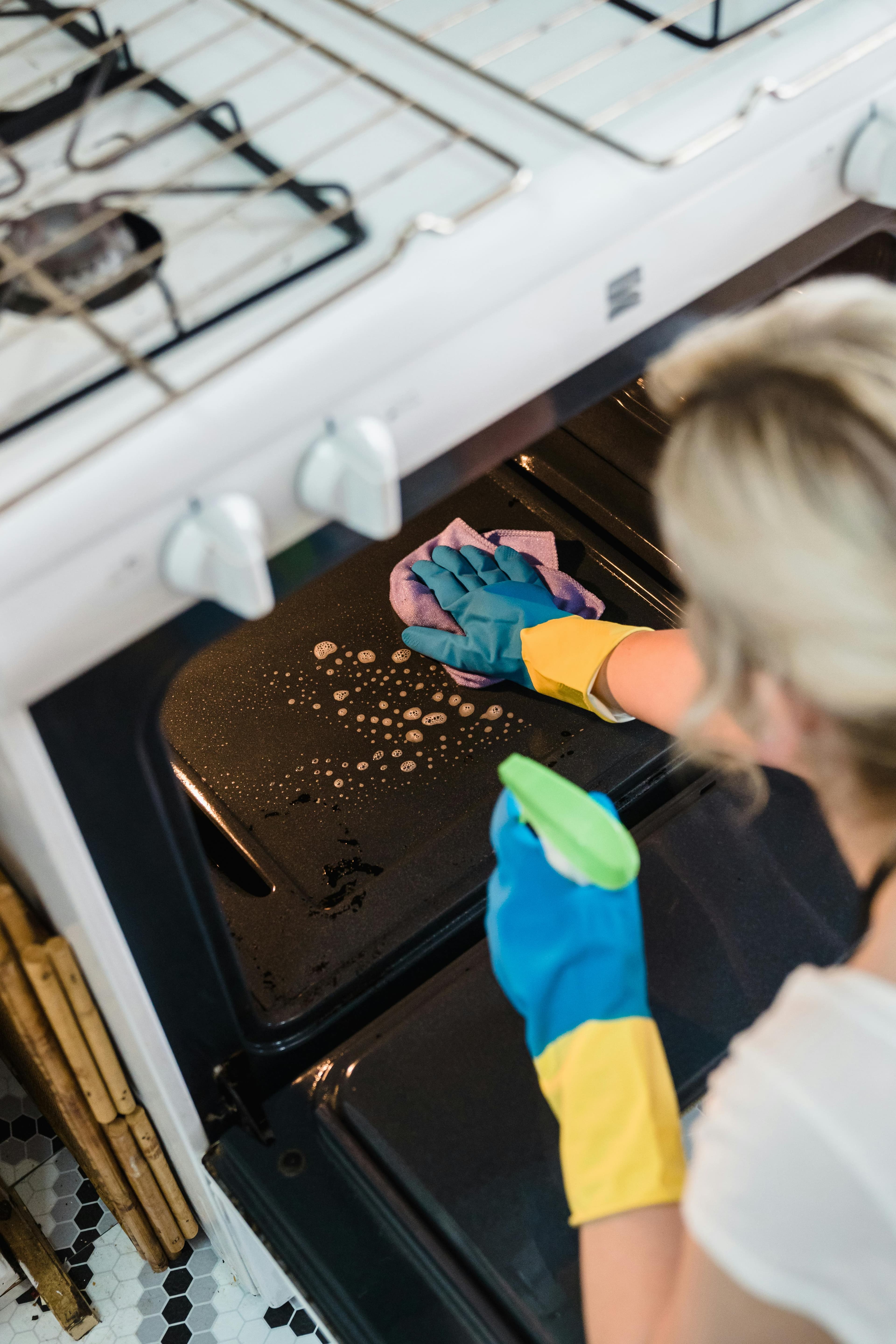 Cleaner doing a deep clean of oven